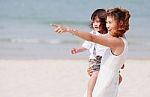 Mom And Son Play On Beach Stock Photo