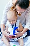 Mother And Baby Girl Using A Smartphone At Home Stock Photo