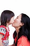 Mother And Daughter Kissing On White Background. Mothers Day Stock Photo