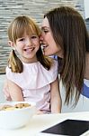 Mother Giving A Kiss To His Daughter On The Cheek Stock Photo