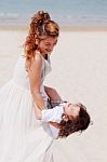 Mother Holding Son On Beach Stock Photo