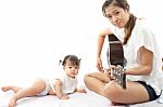 Mother Is Playing A Guitar For Her Baby Stock Photo