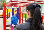 Mother Watching Play On The Playground Daughter Stock Photo