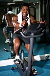 Muscular Man On Excercise Bike At The Gym Stock Photo