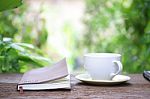 Notebook  And Coffee Cup On Wooden Table Stock Photo