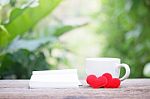 Notepad And Coffee With Heart Decoration On Wooden Table Stock Photo