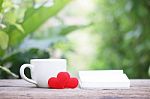 Notepad And Coffee With Heart Decoration On Wooden Table Stock Photo