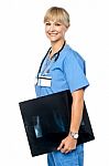 Nurse Holding X-ray Sheet To Be Passed Up To A Senior Doctor Stock Photo