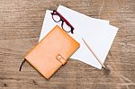 Orange Diary,blank Paper With Pencil And Eye Glasses On Wood Table Stock Photo