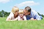 Parents Kissing Their Sweet Angel Stock Photo