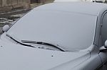 Parked Car Covered With The First Snow In Winter Stock Photo