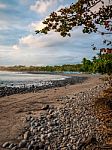 Pebble Beach By The Sea With Cloudy Sky Stock Photo