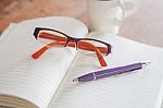 Pen And Eyeglasses On Notebook Stock Photo