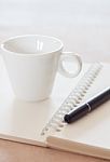 Pen And Spiral Notebook With Coffee Cup Stock Photo