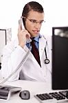 Physician Talking Over Phone Stock Photo