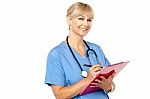 Physician With Clipboard Smiling At Camera Stock Photo