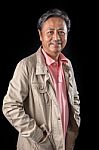 Portrait Close Up Smiling Happiness Face Of 59s Years Old Asian Man With Studio Light Against Black Background Stock Photo