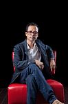 Portrait Face Of 45s Years Old Asian Man Sitting On Red Sofa In Stock Photo