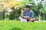 Portrait Of A Concentrated Casual Man In Hat Holding Notebook An Stock Photo