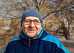 Portrait Of A Smiling Elderly Man Wearing Glasses, A Gray Hat An Stock Photo