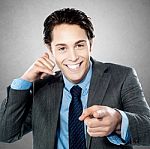 Portrait Of A Young Businessman Gesturing Call Me Sign Stock Photo