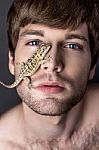 Portrait Of A Young Handsome Man With Lizard On His Face Stock Photo