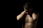 Portrait Of A Young Muscular Man Against Black Stock Photo