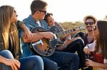 Portrait Of Group Of Friends Playing Guitar And Drinking Beer Stock Photo