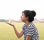 Portrait Of Pretty Young Woman Holding Her Hands Out And Present Stock Photo