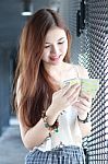 Portrait Of Thai Adult Beautiful Girl Using Her Smart Phone And Smile Stock Photo