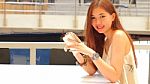 Portrait Of Thai Adult Beautiful Girl Using Her Smart Phone And Smile Stock Photo