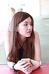 Portrait Of Thai Adult Beautiful Girl Using Her Smart Phone And Smile Stock Photo