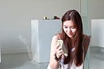 Portrait Of Thai Adult Beautiful Girl Using Her Smart Phone And Smile Stock Photo