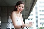 Portrait Of Thai Adult Beautiful Girl Using Her Smart Phone And Smile Stock Photo