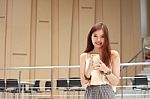 Portrait Of Thai Adult Beautiful Girl Using Her Smart Phone And Smile Stock Photo