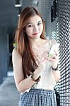 Portrait Of Thai Adult Beautiful Girl Using Her Smart Phone And Smile Stock Photo