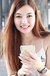 Portrait Of Thai Adult Beautiful Girl Using Her Smart Phone And Smile Stock Photo