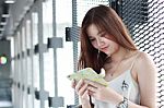 Portrait Of Thai Adult Beautiful Girl Using Her Smart Phone And Smile Stock Photo