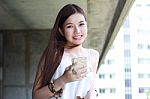 Portrait Of Thai Adult Beautiful Girl Using Her Smart Phone And Smile Stock Photo