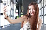 Portrait Of Thai Adult Beautiful Girl Using Her Smart Phone Selfie Stock Photo