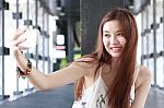 Portrait Of Thai Adult Beautiful Girl Using Her Smart Phone Selfie Stock Photo