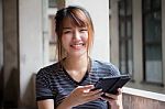 Portrait Of Thai Adult Beautiful Girl Using Her Tablet Stock Photo