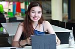 Portrait Of Thai Adult Beautiful Girl Using Her Tablet And Smile In University Stock Photo