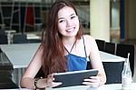 Portrait Of Thai Adult Beautiful Girl Using Her Tablet And Smile In University Stock Photo