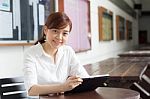 Portrait Of Thai Adult Businesswoman Beautiful Girl Using Her Tablet Stock Photo