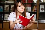 Portrait Of Thai Adult Student University Uniform Beautiful Girl Reading Red Book Stock Photo