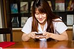 Portrait Of Thai Adult Student University Uniform Beautiful Girl Using Her Smart Phone Stock Photo