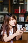 Portrait Of Thai Adult Student University Uniform Beautiful Girl Using Her Smart Phone Stock Photo