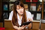 Portrait Of Thai Adult Student University Uniform Beautiful Girl Using Her Tablet Stock Photo