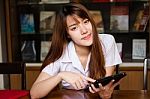 Portrait Of Thai Adult Student University Uniform Beautiful Girl Using Her Tablet Stock Photo